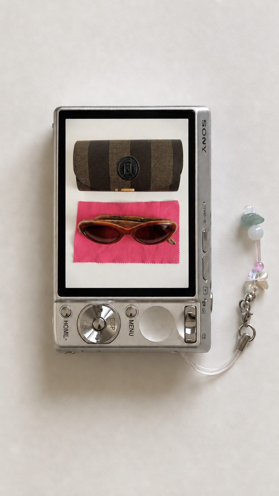 Vintage striped case and tortoiseshell sunglasses, shot on a compact camera screen