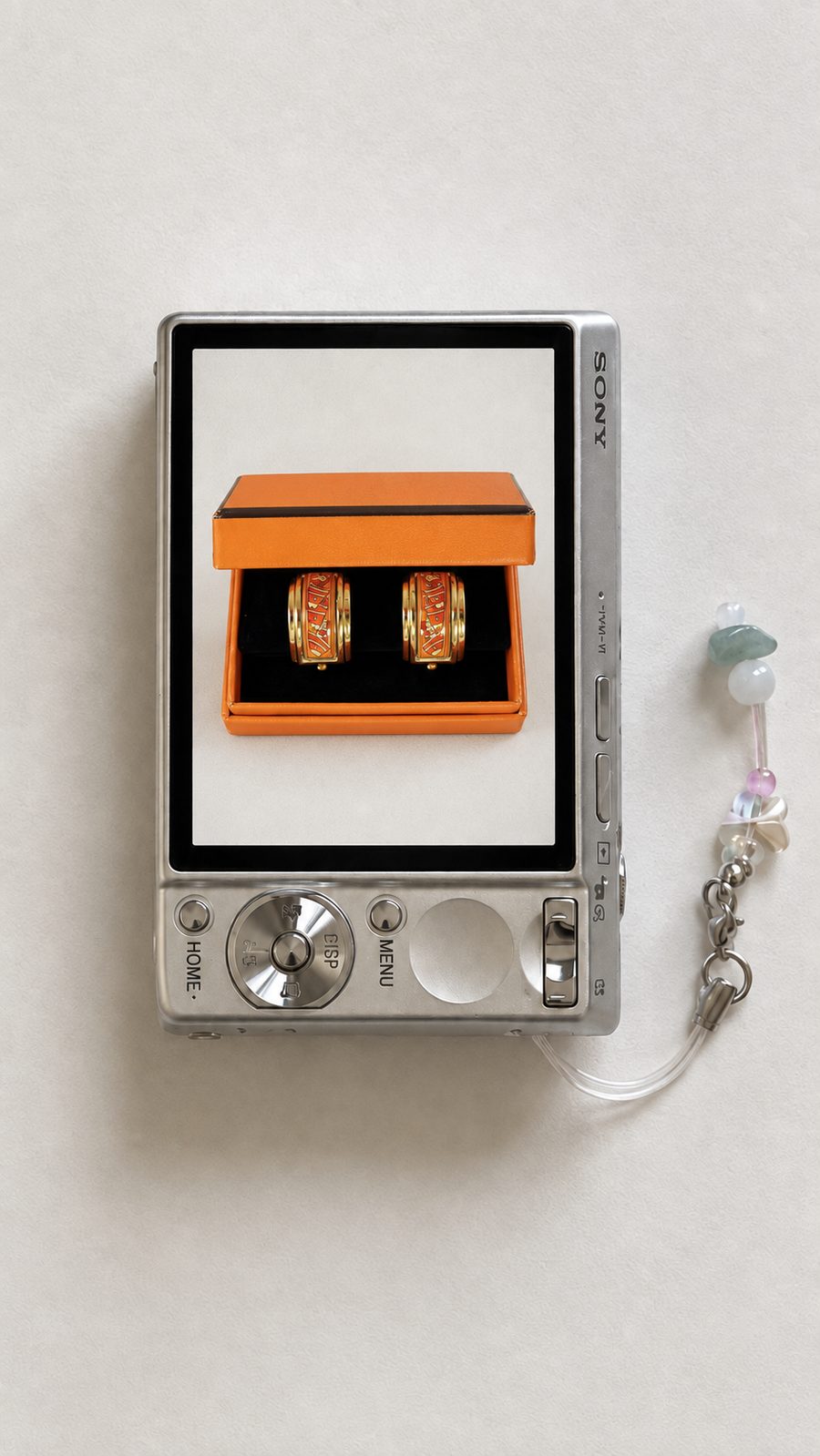 Gold and orange enamel earrings in an orange box