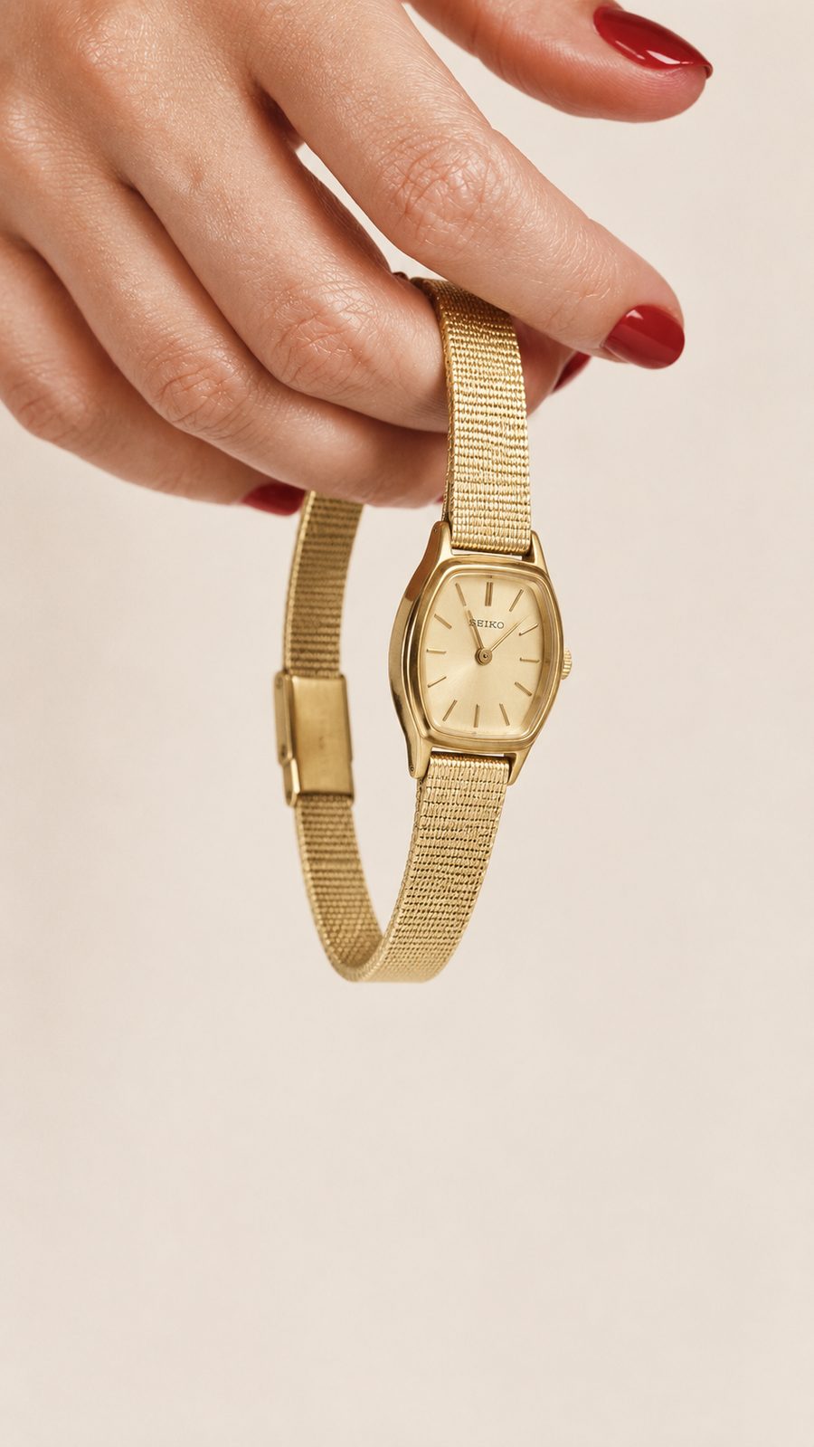 Gold mesh Seiko watch held by hand